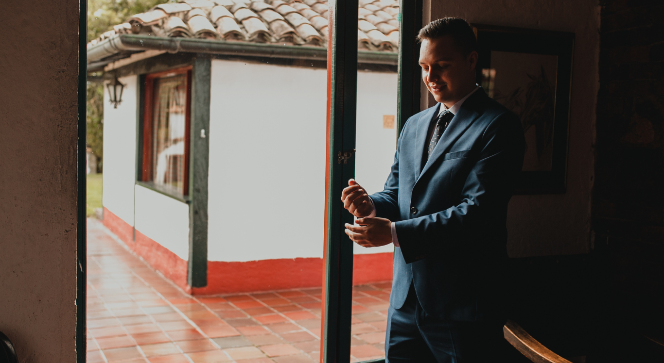 Novio ajustándose el traje en patio rústico