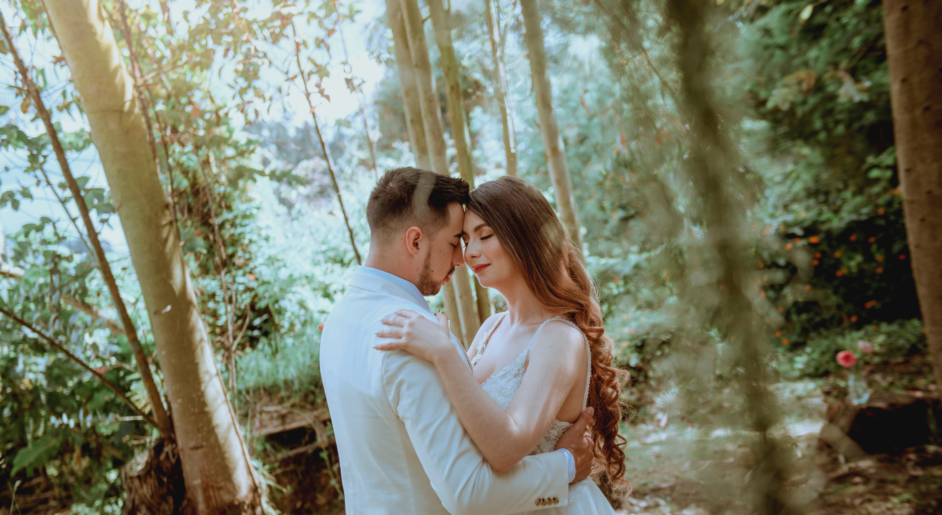 Pareja de novios en bosque, momento íntimo