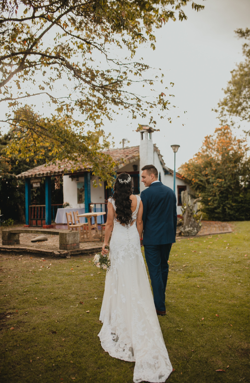 Novios caminando de espaldas por el jardín