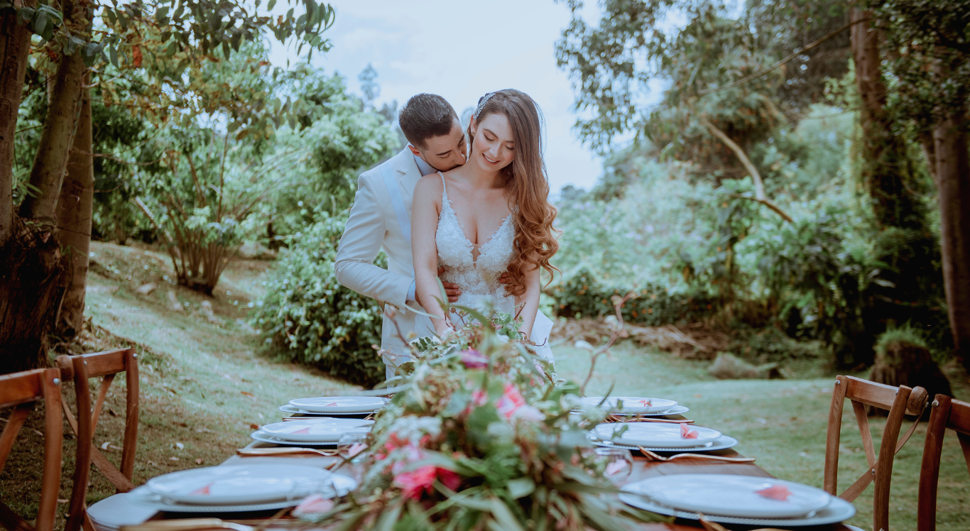 Novios en mesa de jardín con centro floral